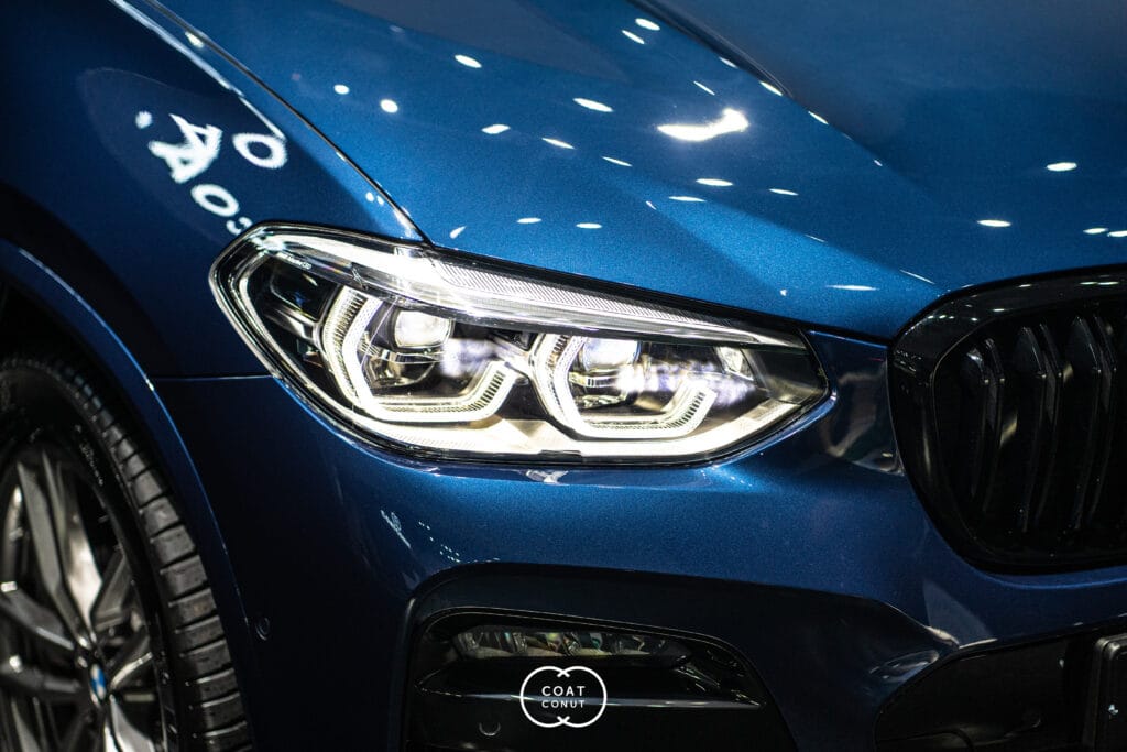 Blue BMW front quarter panel and headlight photographed in the studio